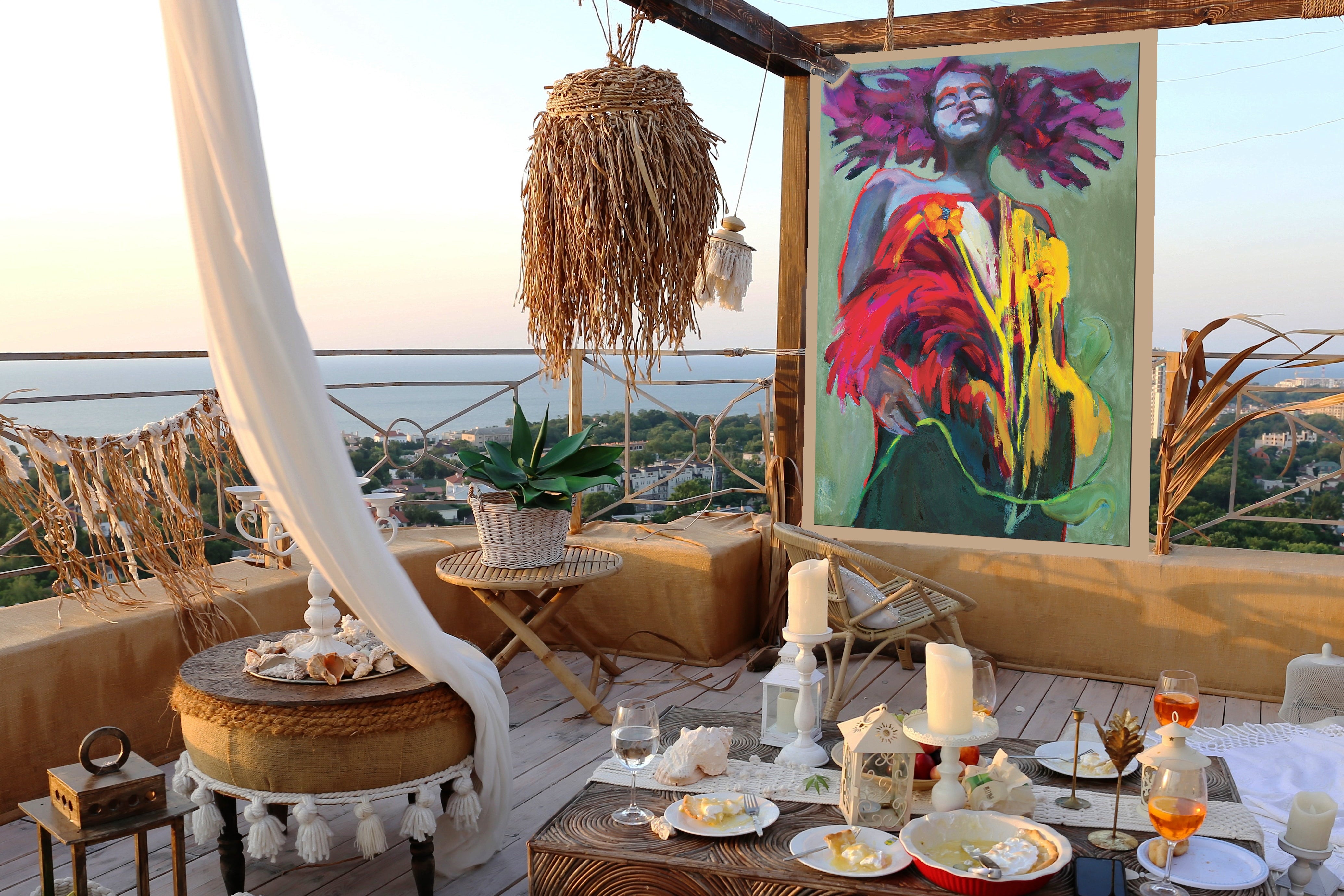 Coastal outdoor setting with  a colorful OPEN AIR Collection figurative painting on a balcony with ocean view.
