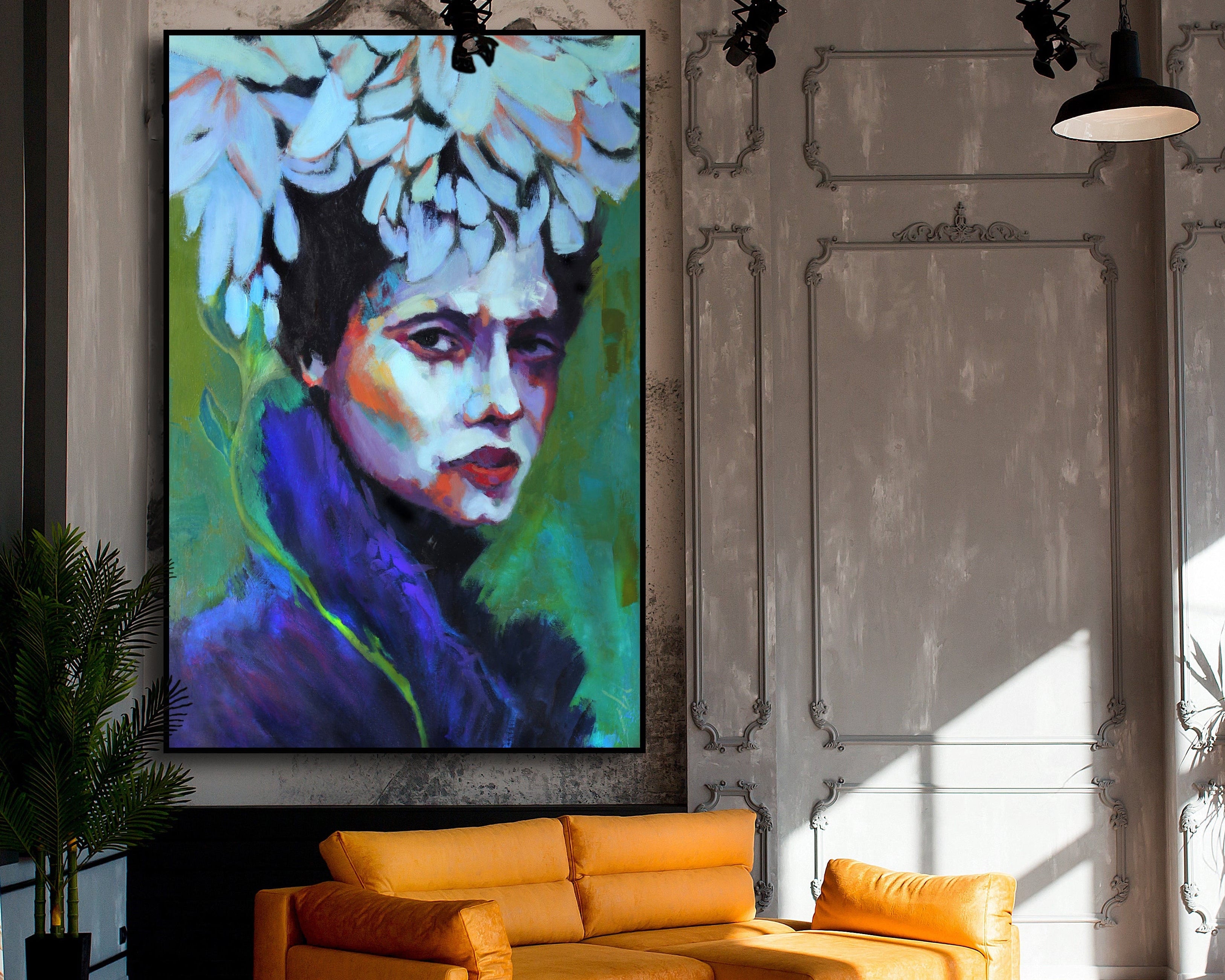 Statement painting of a colorful woman's face above an orange sofa in a stylish room.